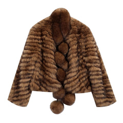 A brown fur coat with a braided collar and pom poms hanging from the bottom.