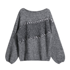 A gray knitted sweater with a unique cutout design on the front.