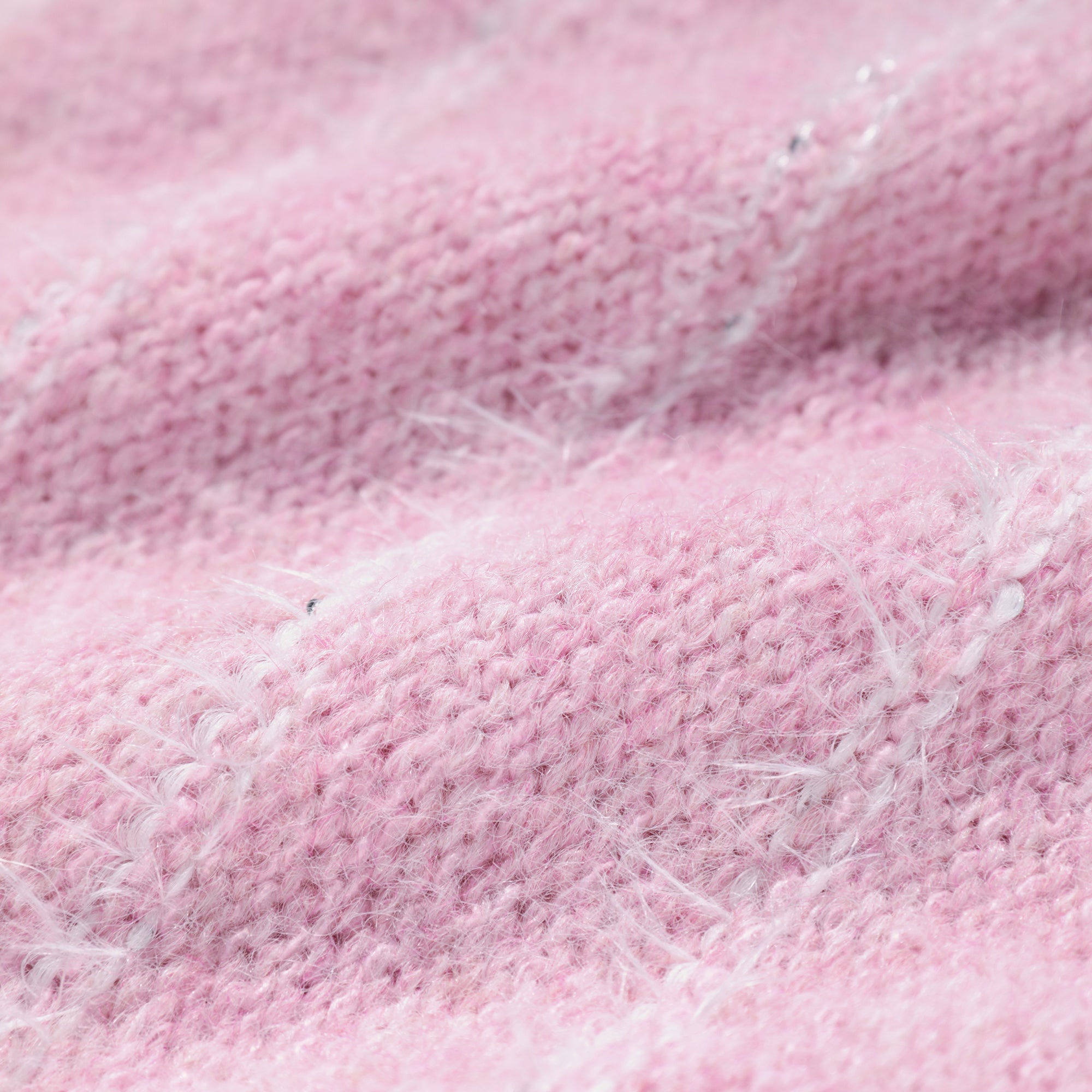 A close-up image of a soft, pink knitted fabric with visible stitches and texture.
