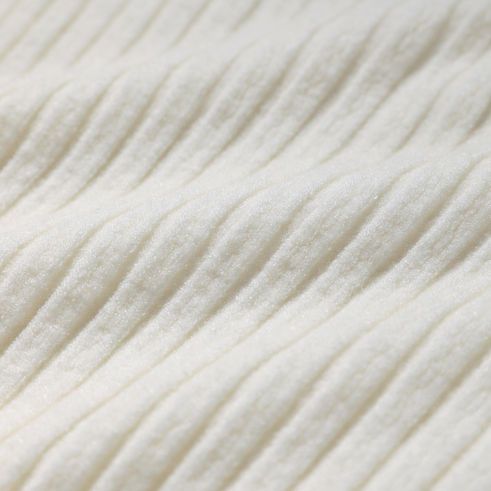 A close-up image of a white fabric with a textured, ribbed appearance.
