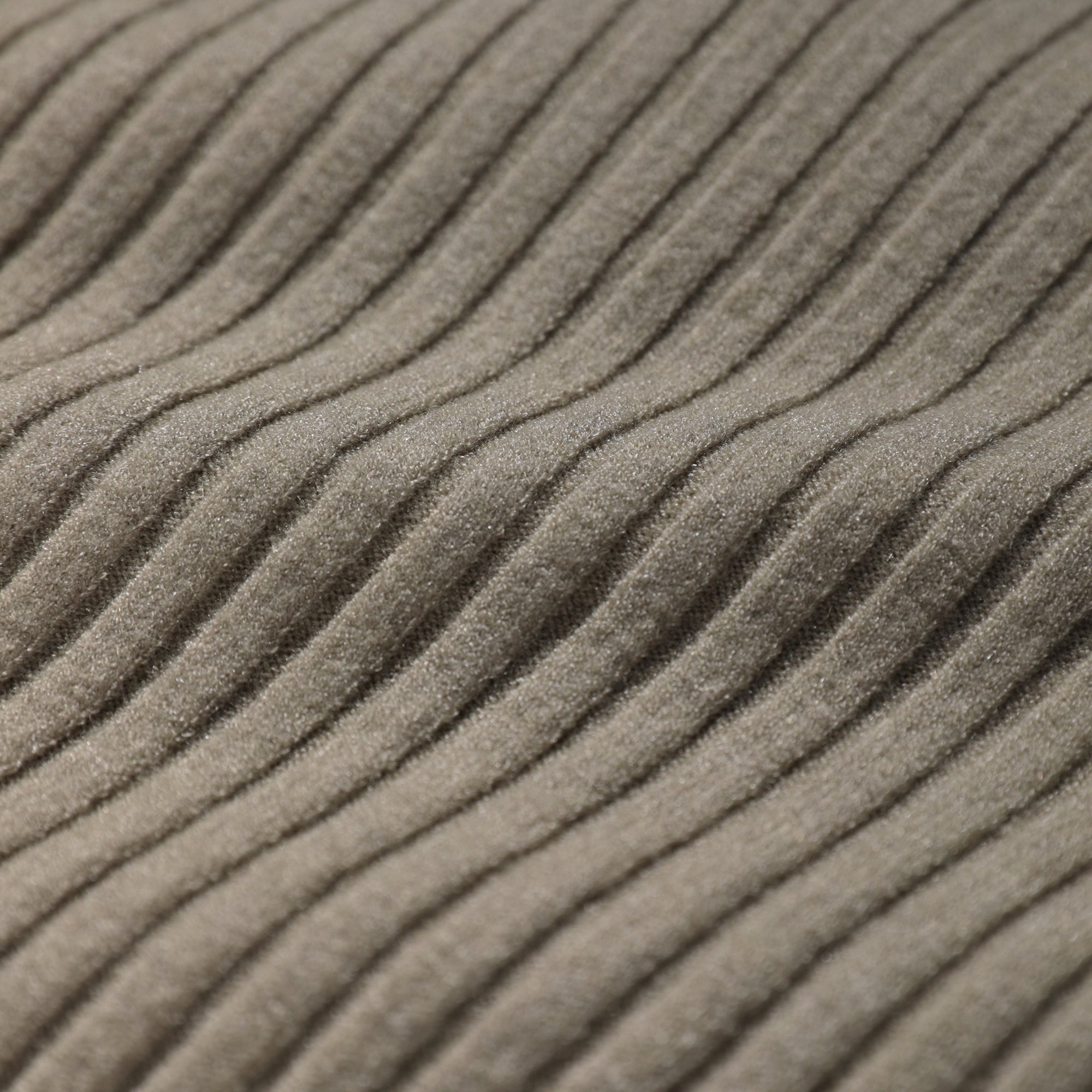A close-up image of a textured fabric, likely a sweater or garment, with a ribbed or criss-cross pattern.