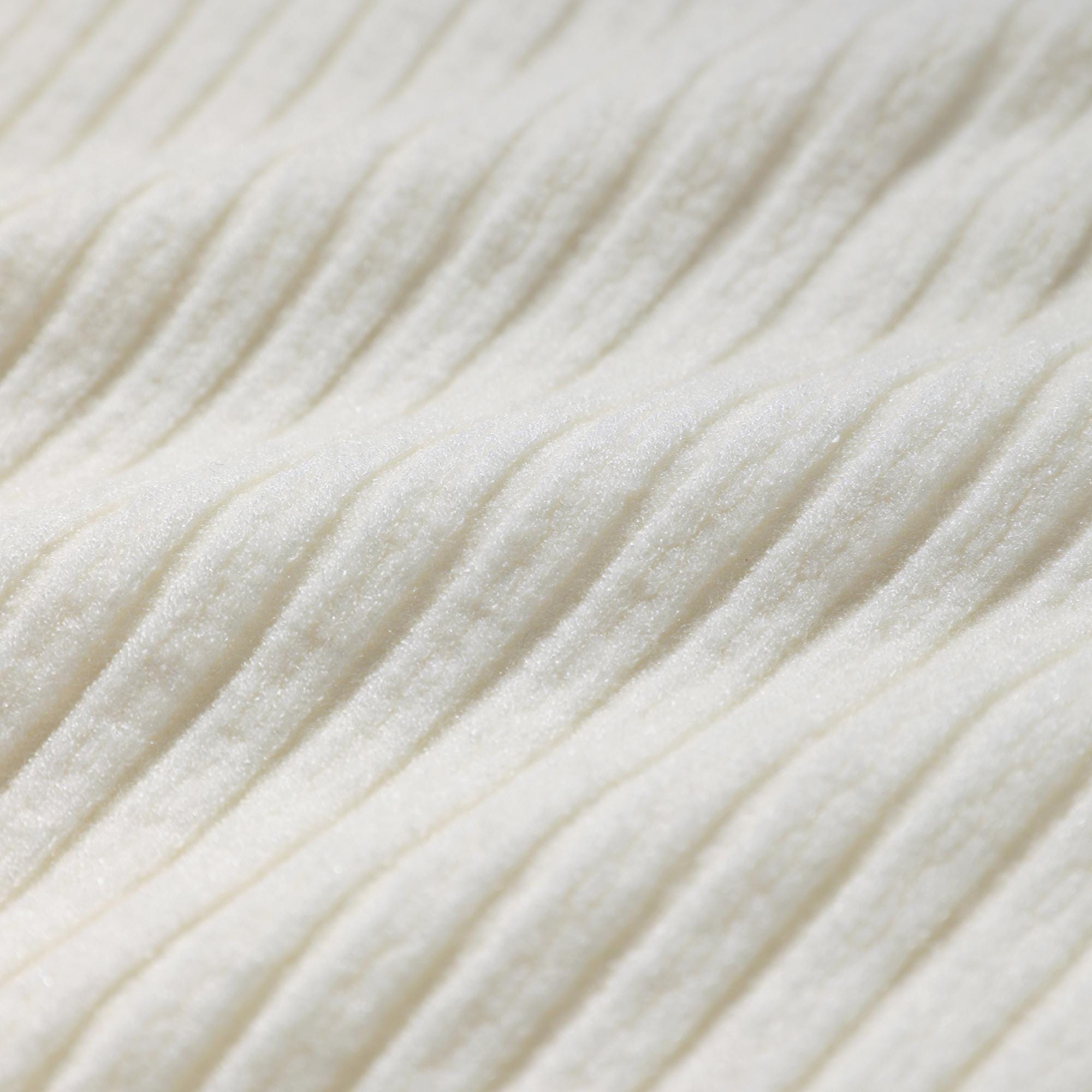 A close-up image of a white fabric with a textured, ribbed appearance.