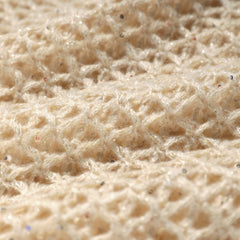 A close-up image of a soft, beige fabric with a textured, woven pattern.