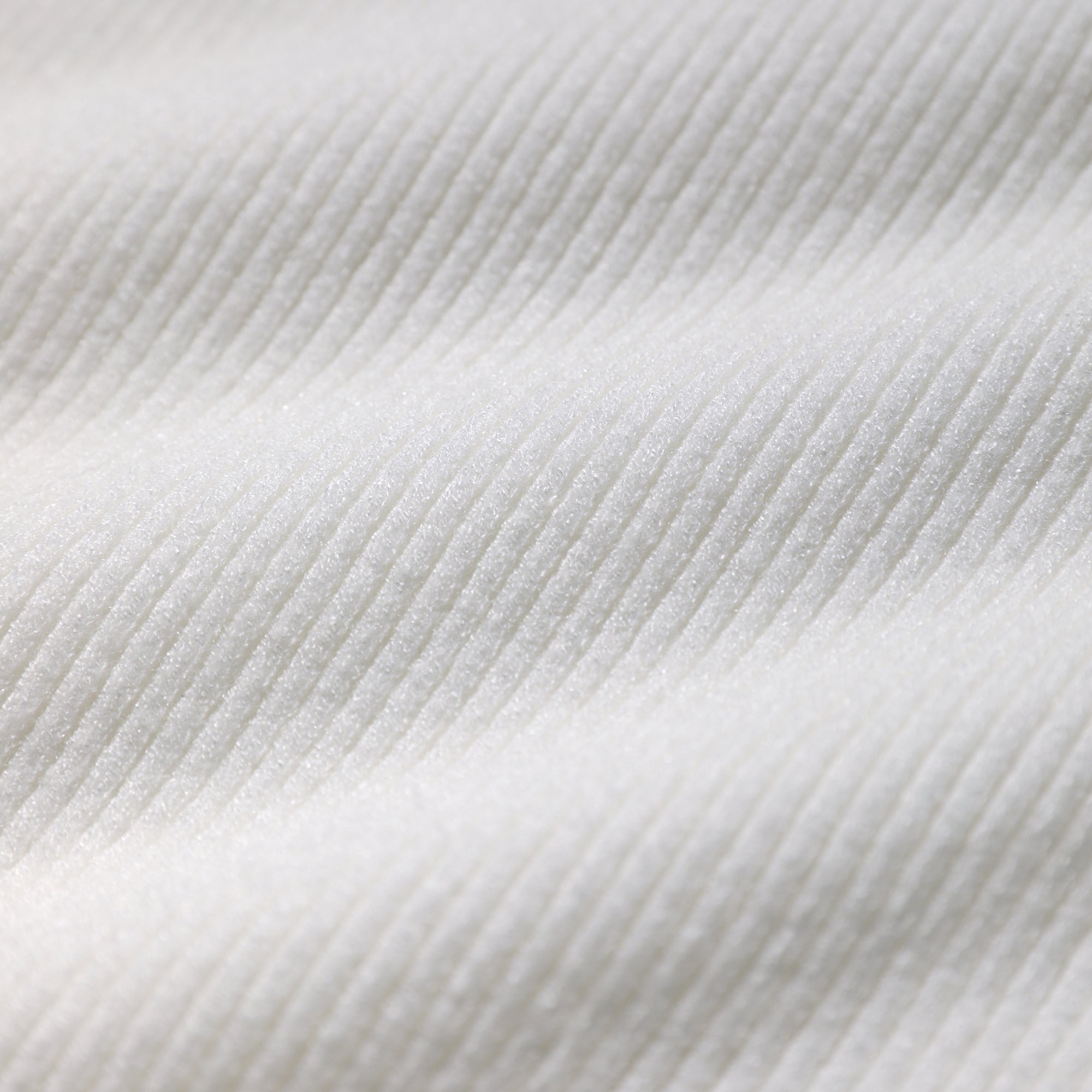 A close-up image of a white fabric with a textured, ribbed appearance.