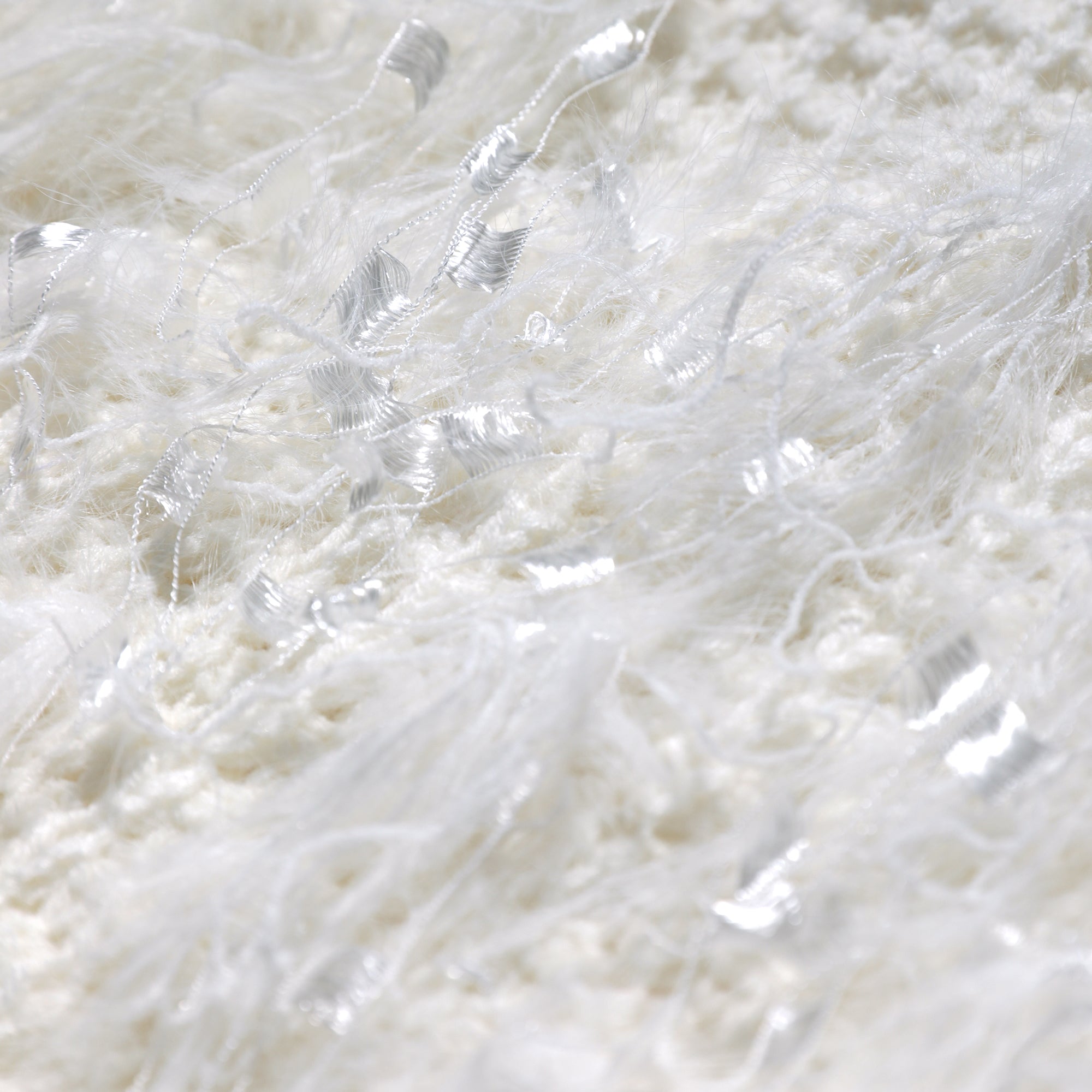 The image is a close-up of a white, fluffy material with a slightly fuzzy texture.
