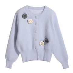 A light purple cardigan with white and gray floral embellishments on the front.