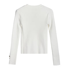 A white long-sleeved sweater with a ribbed texture.