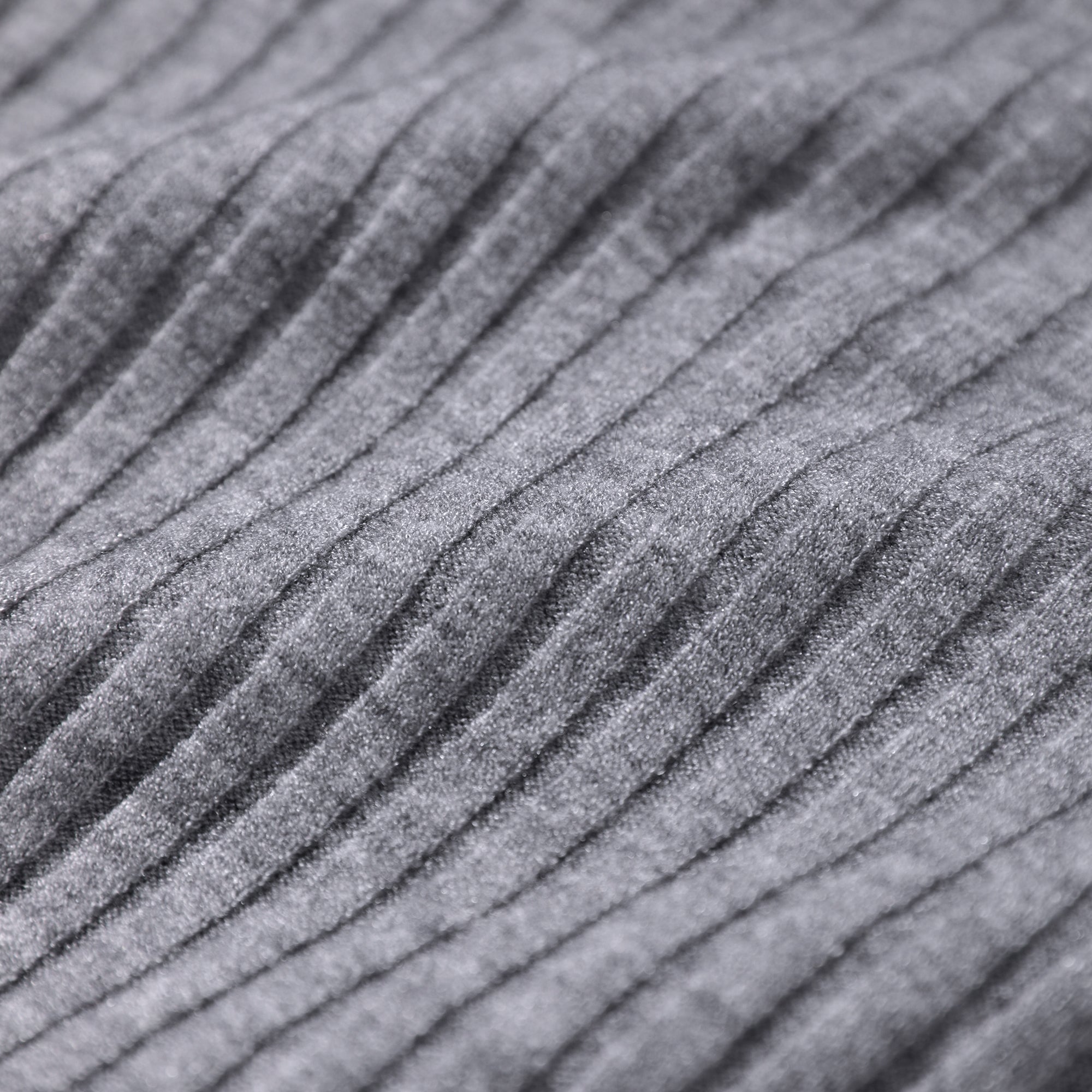A close-up image of a gray, textured fabric with a ribbed or pleated pattern.