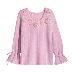 A pink knitted sweater with a v-neck and floral embellishments on the front.