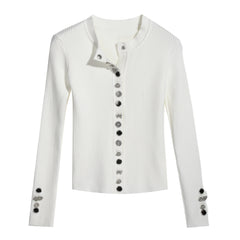 A white long-sleeved cardigan with black buttons and embellishments on the sleeves.