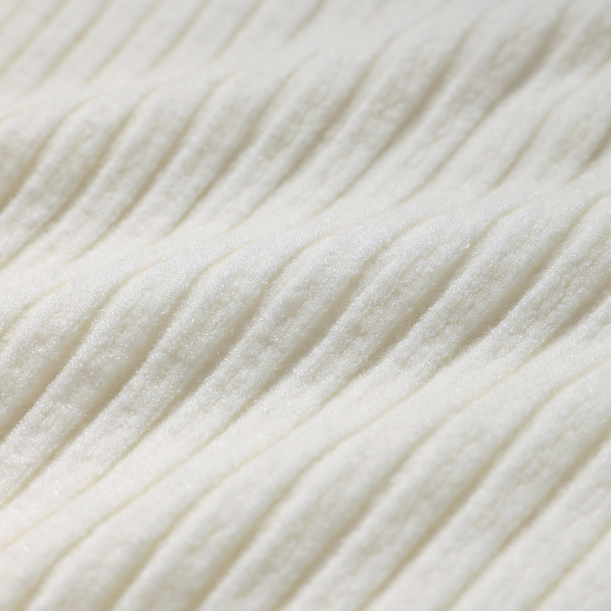 A close-up image of a white fabric with a textured, ribbed appearance.