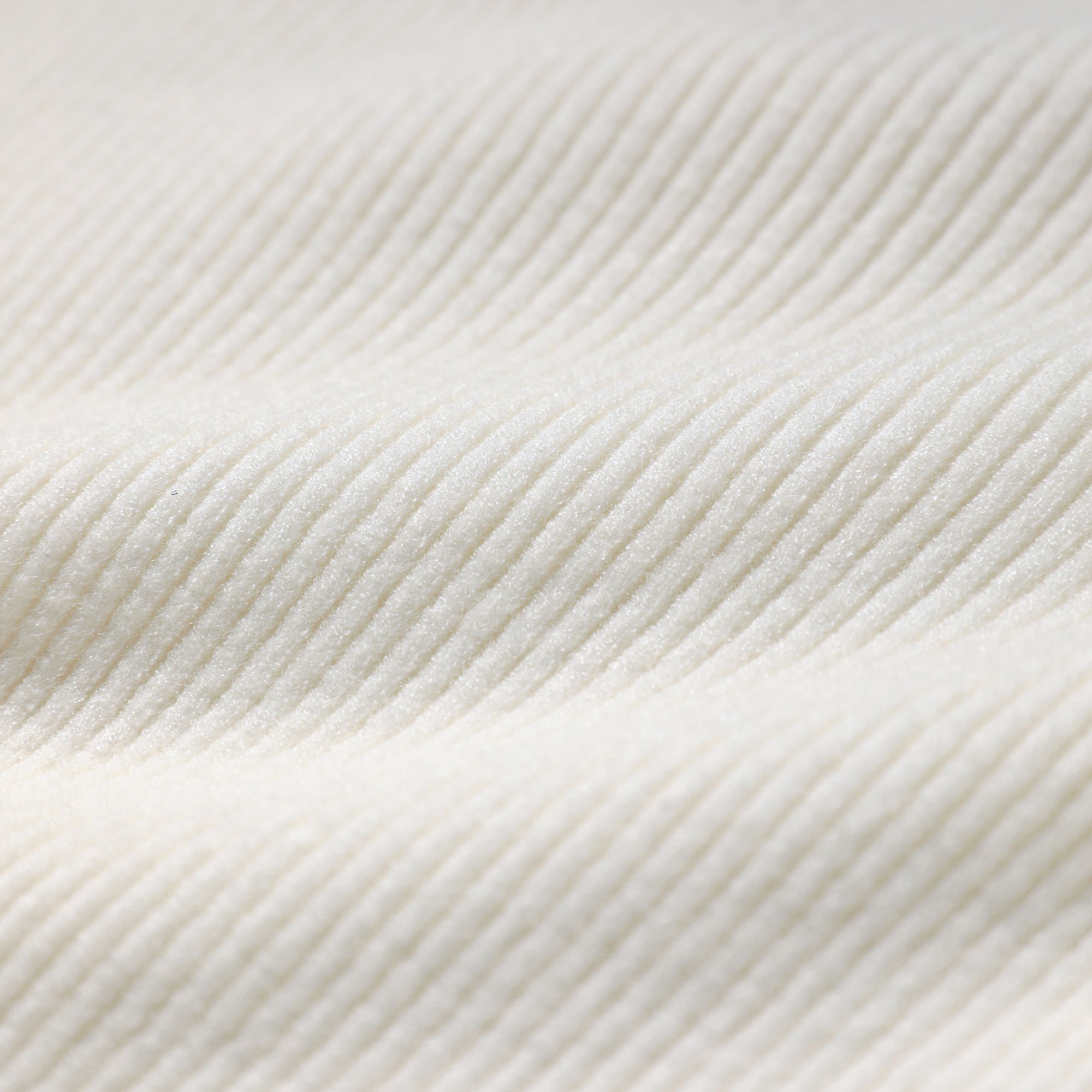 A close-up image of a white fabric with a textured, ribbed appearance.