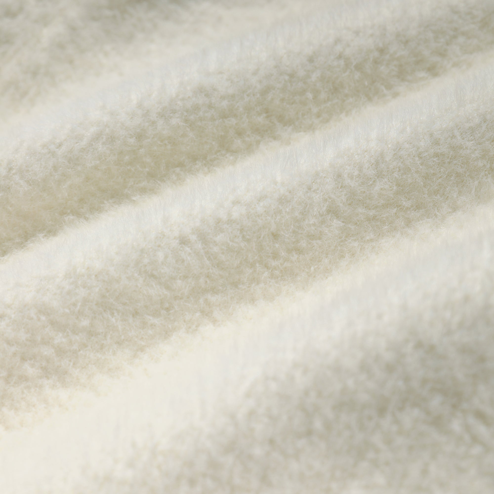 A close-up view of a soft, fluffy white fabric, such as a blanket or a piece of clothing.