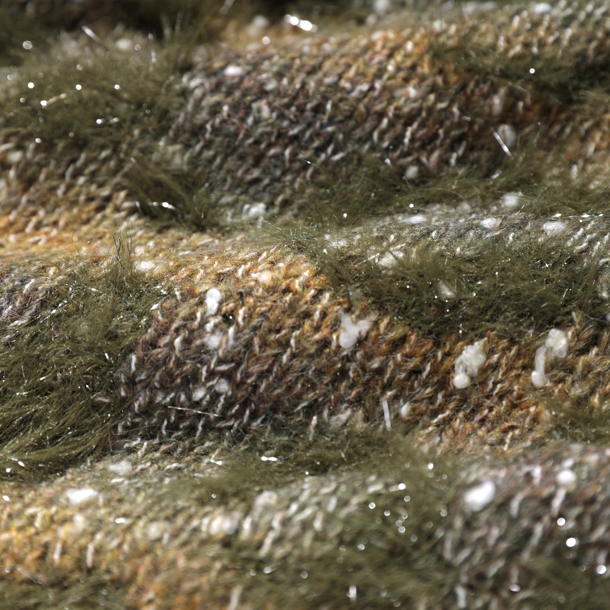 The image is a close-up of a fuzzy, textured fabric with a mix of green, brown, and white colors.