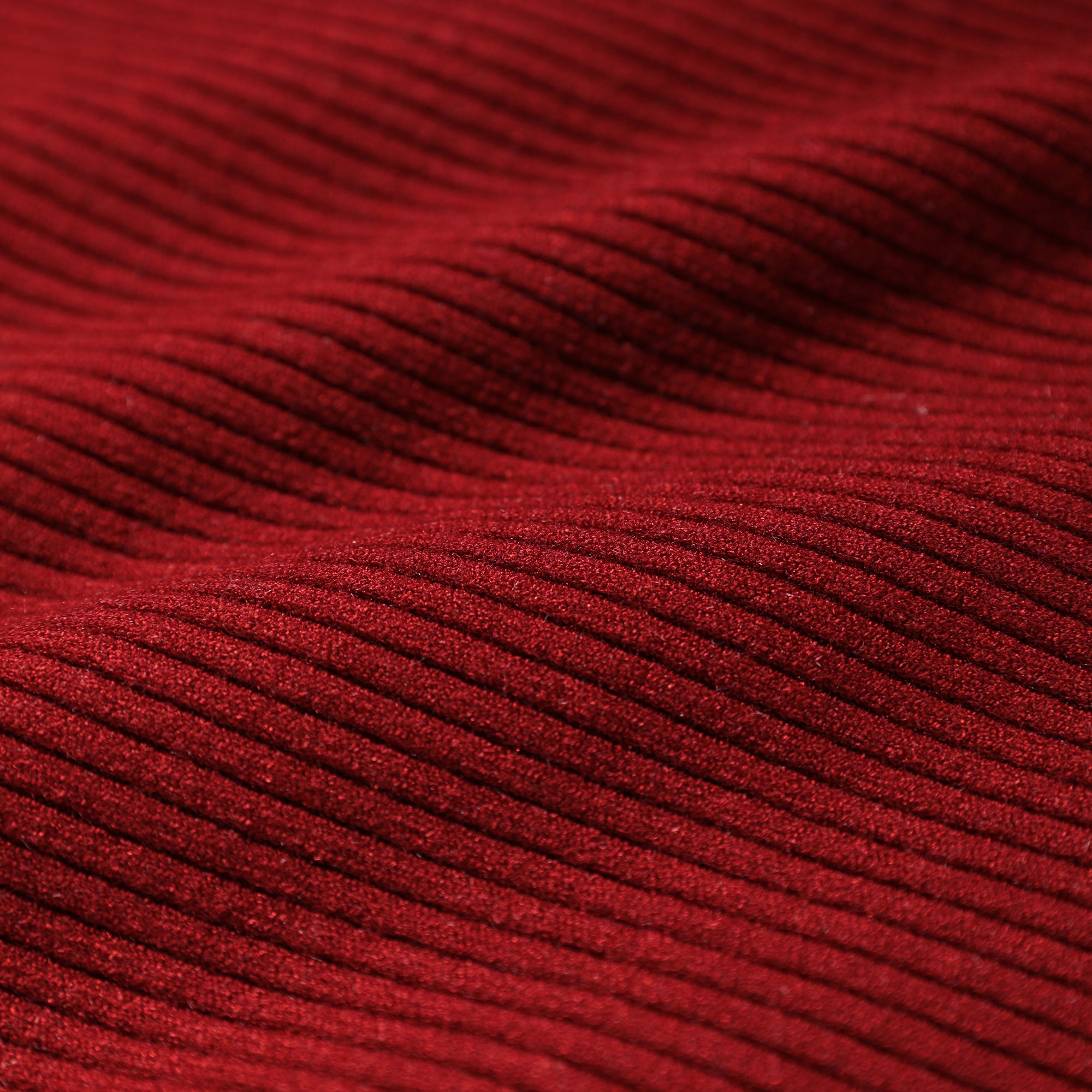 a close-up view of a red fabric with a textured, ribbed appearance.