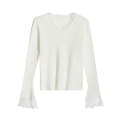 A white long-sleeved shirt with lace trim on the sleeves and collar.