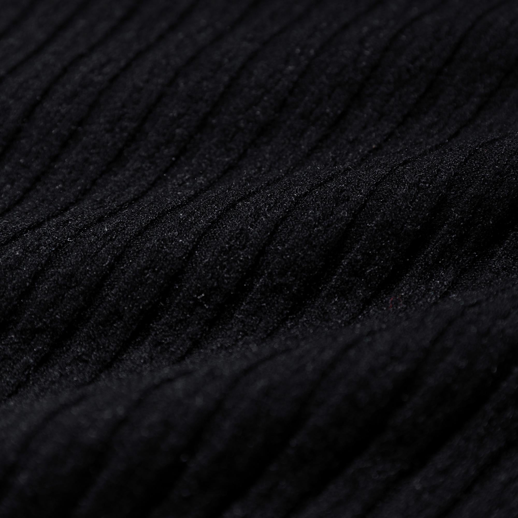 The image is a close-up of a black fabric with a textured, ribbed appearance.