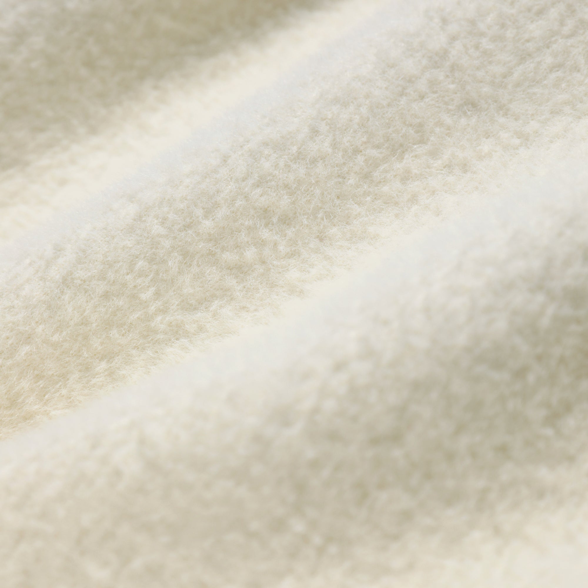 A close-up image of a soft, fluffy white fabric, such as a blanket or a piece of clothing.