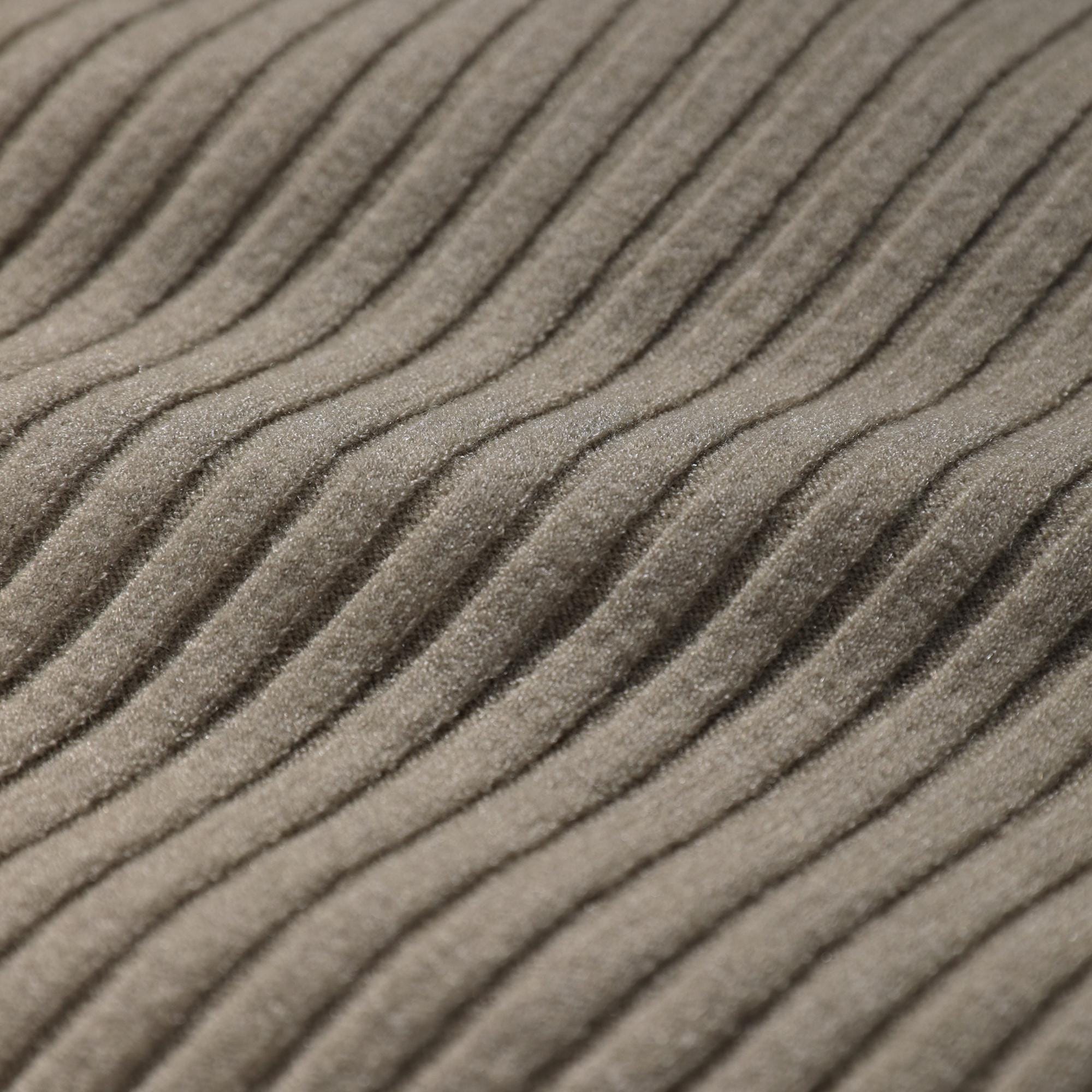 A close-up image of a textured fabric, likely a sweater or garment, with a ribbed or criss-cross pattern.