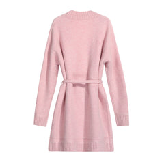 A pink knitted dress with a tie waist and long sleeves.