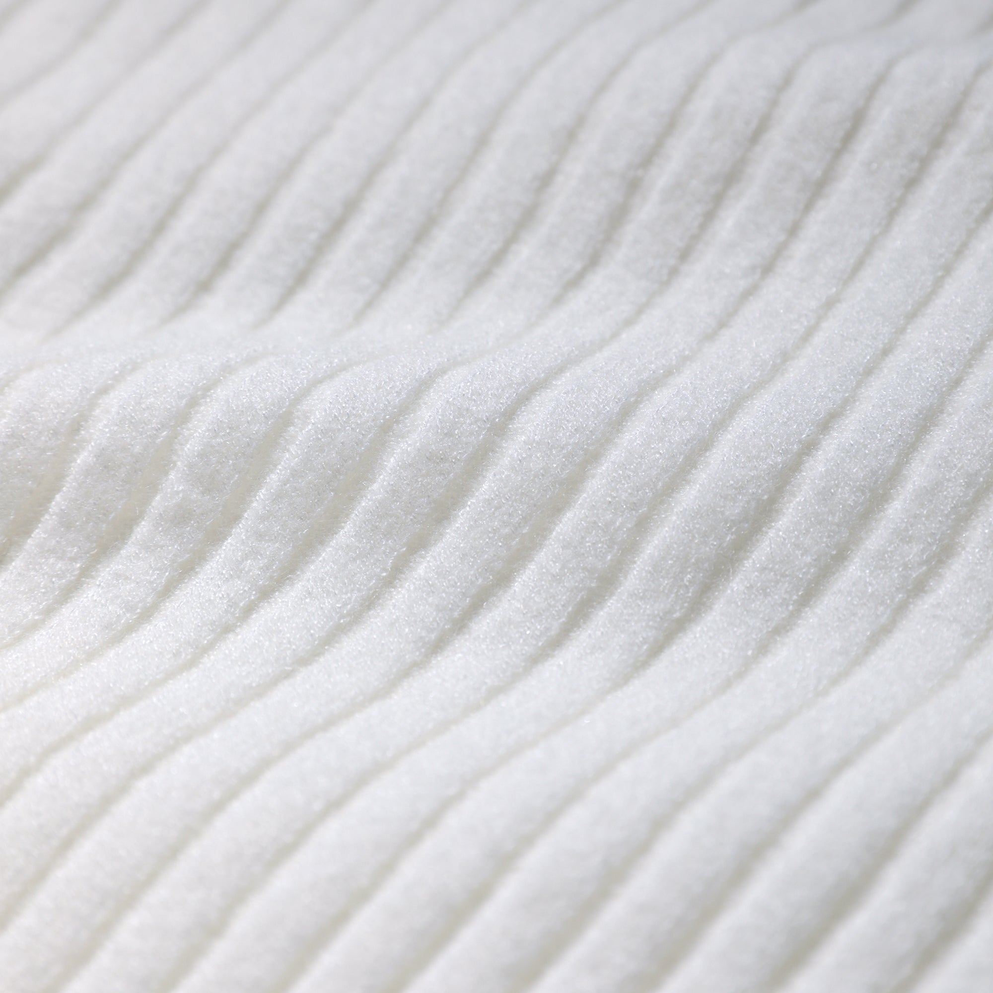 A close-up image of a white fabric with a ribbed texture, featuring a repeating diagonal pattern.